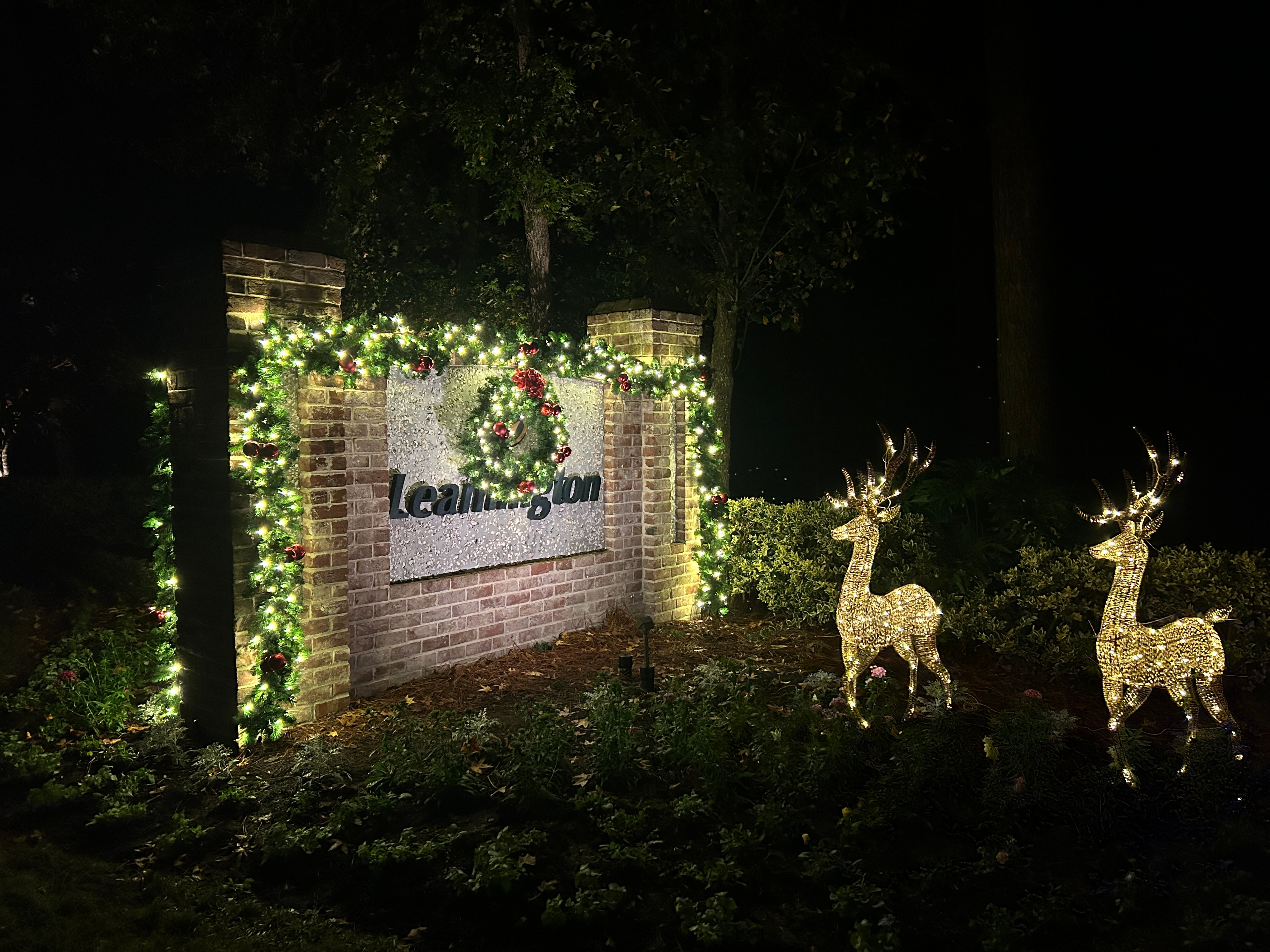 Leamington community entrance sign decorated with garland, lights, and illuminated reindeer
