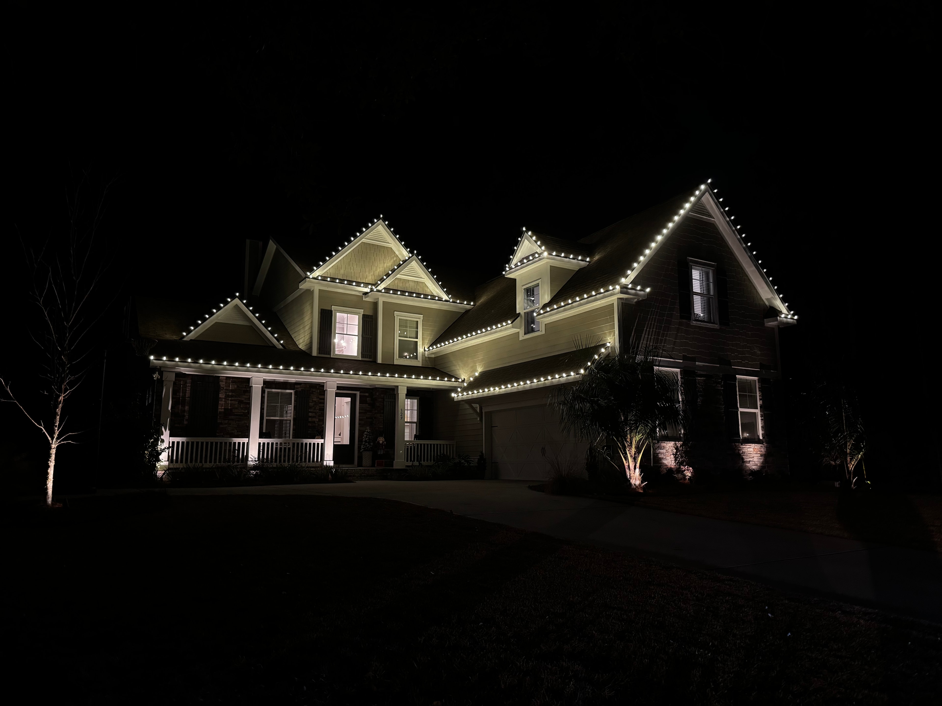 Residential home with crisp white roofline holiday lights outlining every gable and eave